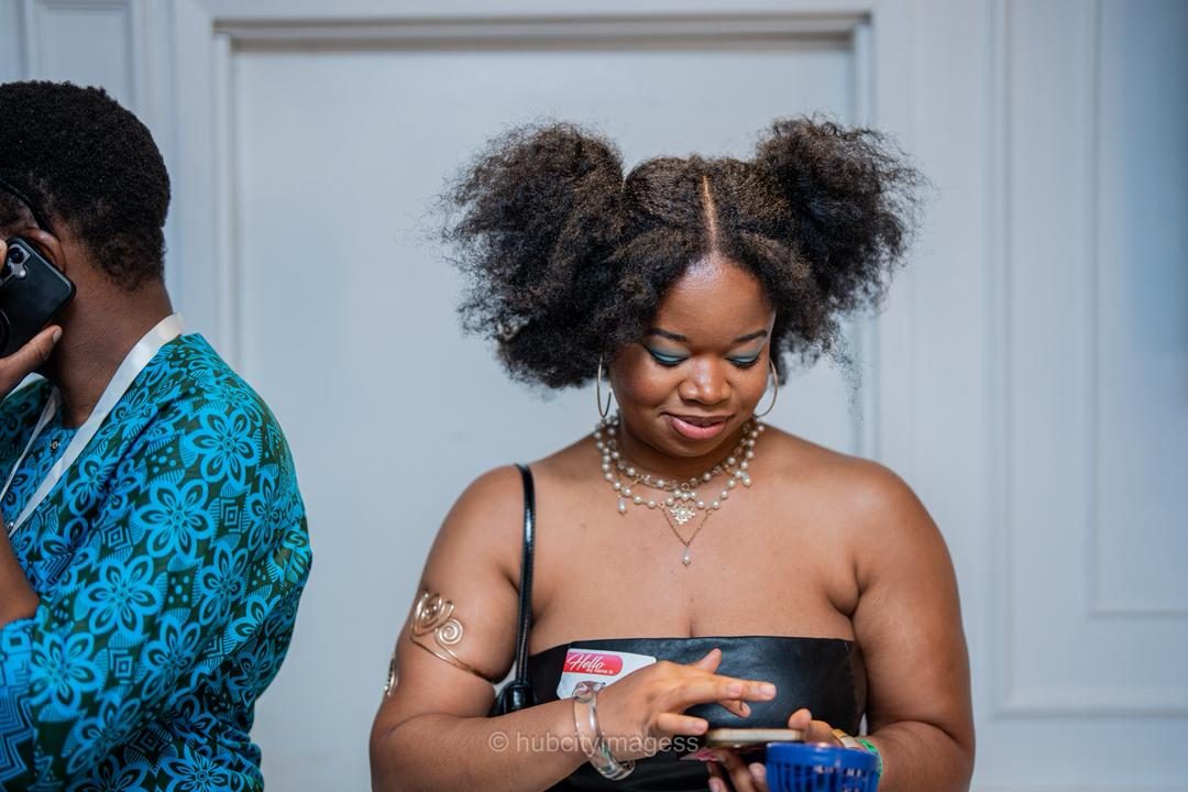 Guest checking her phone beside a friend at an indoor linkup