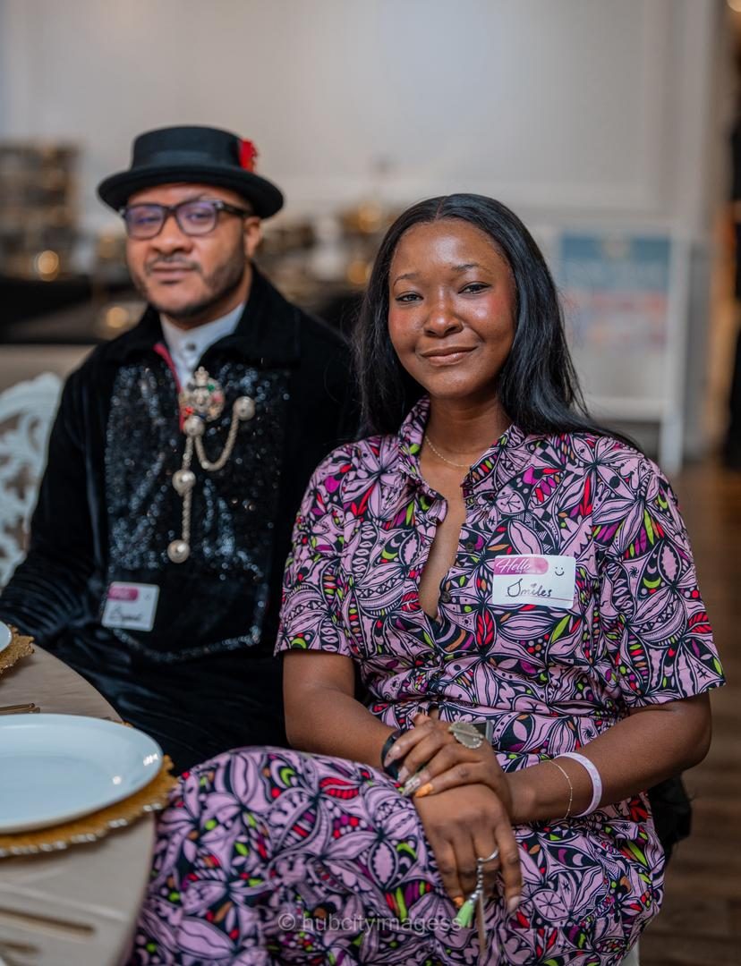 Two guests in bold prints seated together at a dinner table