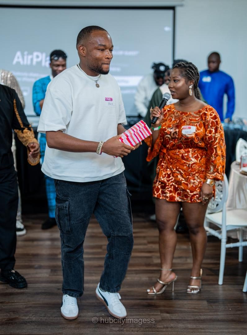 Host handing a wrapped gift to a guest during a games segment