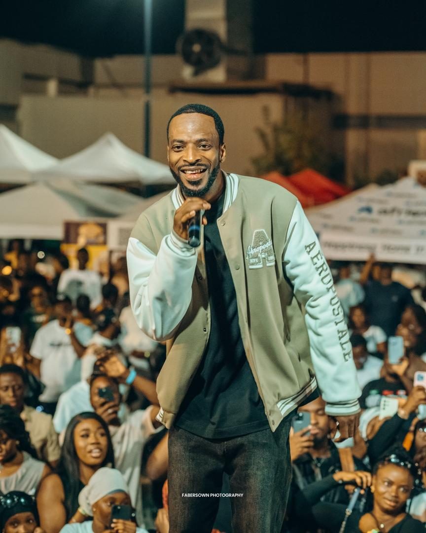 Artist performing to a packed outdoor festival crowd