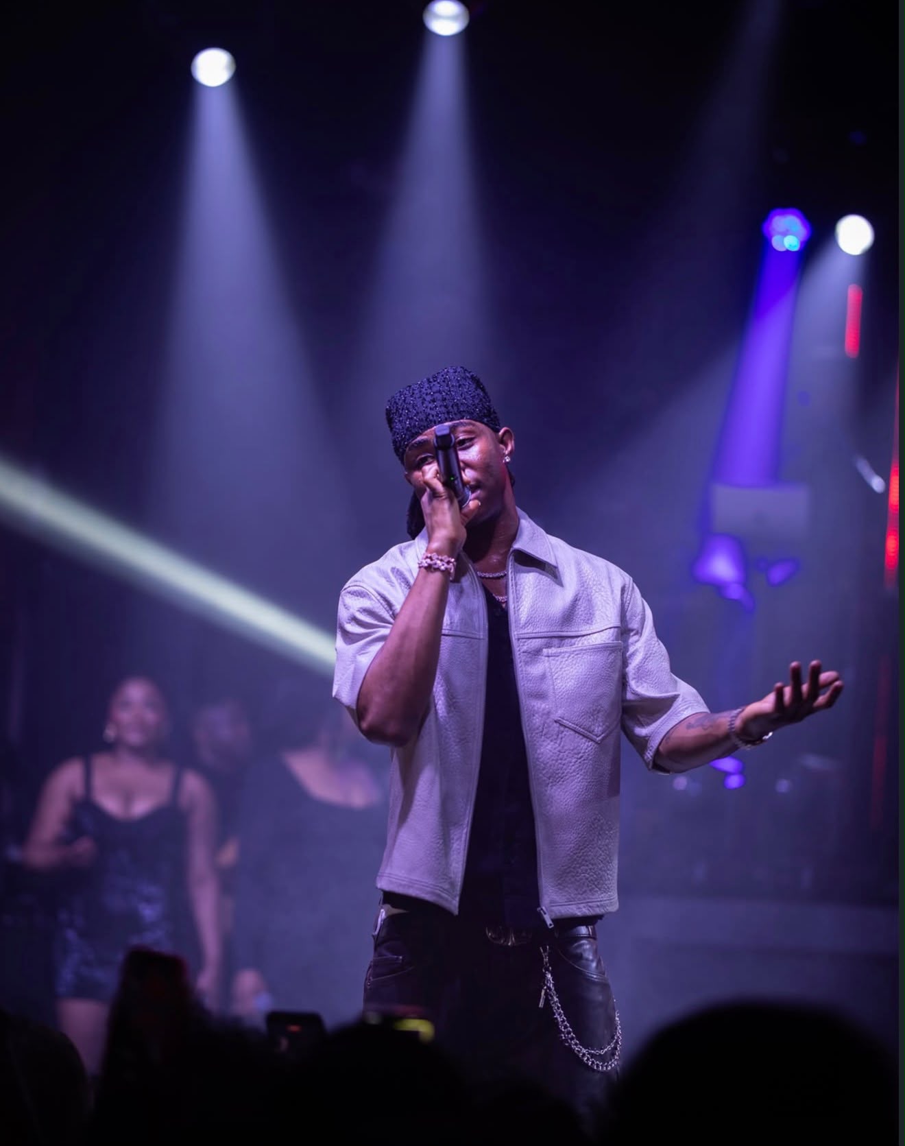 Singer performing beneath dramatic concert lighting